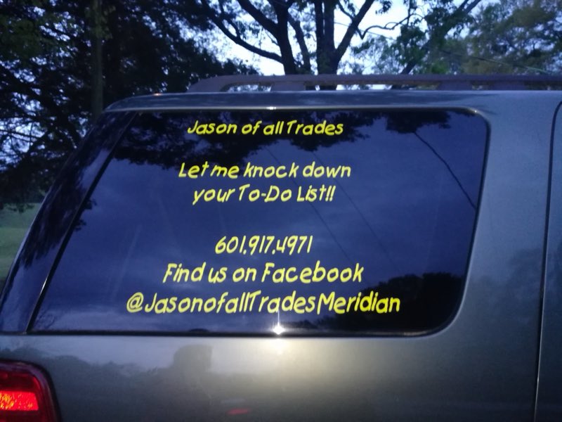 Jason of all Trades name and slogan lettered on the rear window of the work van